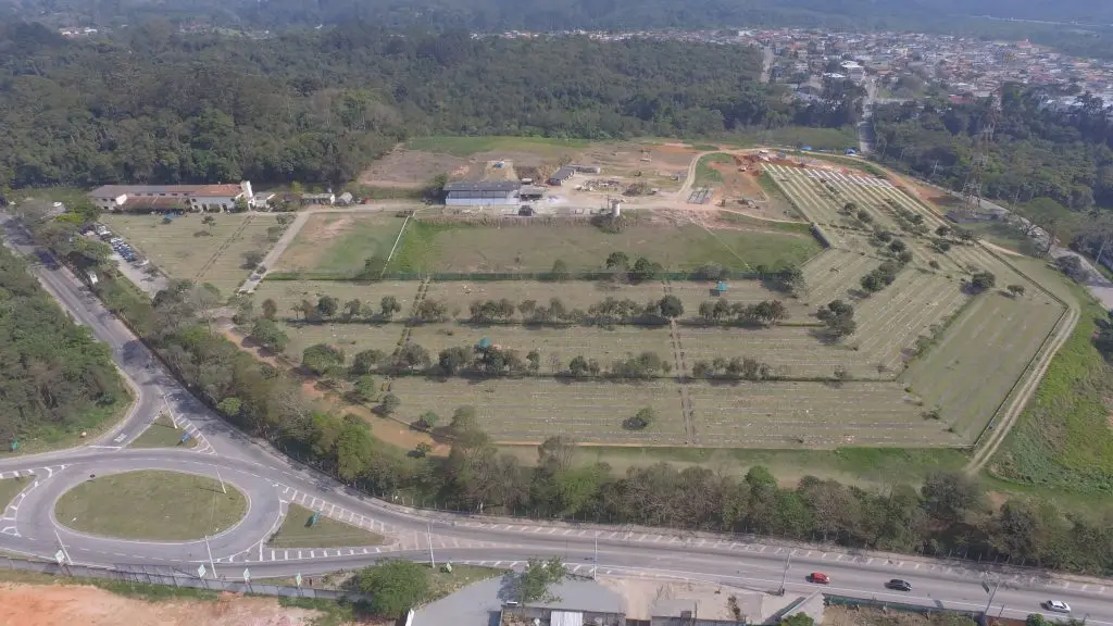 Vista aérea do Parque dos Ipês, com o gramado em faixas e a reserva de mata ao fundo.